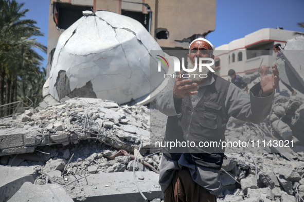 A Palestinian man is reacting near the Abu Bakr Al-Siddiq Mosque, which has been leveled by Israeli bombardment in Deir Al-Balah, in the cen...