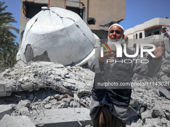 A Palestinian man is reacting near the Abu Bakr Al-Siddiq Mosque, which has been leveled by Israeli bombardment in Deir Al-Balah, in the cen...