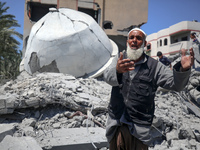 A Palestinian man is reacting near the Abu Bakr Al-Siddiq Mosque, which has been leveled by Israeli bombardment in Deir Al-Balah, in the cen...