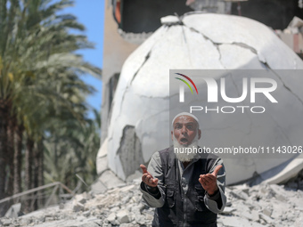 A Palestinian man is reacting near the Abu Bakr Al-Siddiq Mosque, which has been leveled by Israeli bombardment in Deir Al-Balah, in the cen...