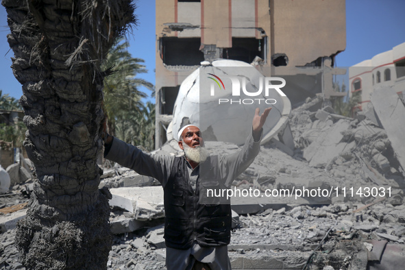 A Palestinian man is reacting near the Abu Bakr Al-Siddiq Mosque, which has been leveled by Israeli bombardment in Deir Al-Balah, in the cen...