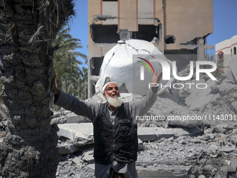 A Palestinian man is reacting near the Abu Bakr Al-Siddiq Mosque, which has been leveled by Israeli bombardment in Deir Al-Balah, in the cen...