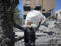 A Palestinian man is reacting near the Abu Bakr Al-Siddiq Mosque, which has been leveled by Israeli bombardment in Deir Al-Balah, in the cen...