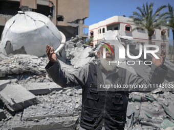 A Palestinian man is reacting near the Abu Bakr Al-Siddiq Mosque, which has been leveled by Israeli bombardment in Deir Al-Balah, in the cen...