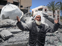 A Palestinian man is reacting near the Abu Bakr Al-Siddiq Mosque, which has been leveled by Israeli bombardment in Deir Al-Balah, in the cen...