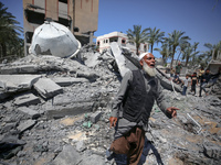 A Palestinian man is reacting near the Abu Bakr Al-Siddiq Mosque, which has been leveled by Israeli bombardment in Deir Al-Balah, in the cen...