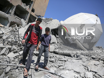 Palestinians are inspecting the damage in the rubble of Abu Bakr Al-Siddiq Mosque, which was leveled by Israeli bombardment in Deir Al-Balah...