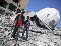 Palestinians are inspecting the damage in the rubble of Abu Bakr Al-Siddiq Mosque, which was leveled by Israeli bombardment in Deir Al-Balah...