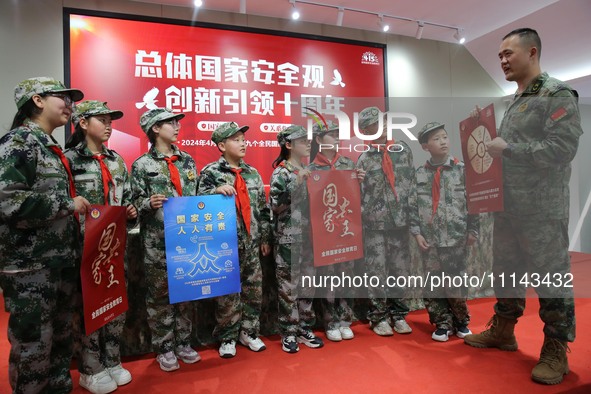 A military experience camp instructor is explaining national security knowledge to primary school students in Lianyungang, East China's Jian...