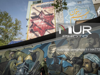 An Iranian woman is walking under anti-Israeli murals in downtown Tehran, Iran, on April 13, 2024. The Prime Minister of Israel, Benjamin Ne...