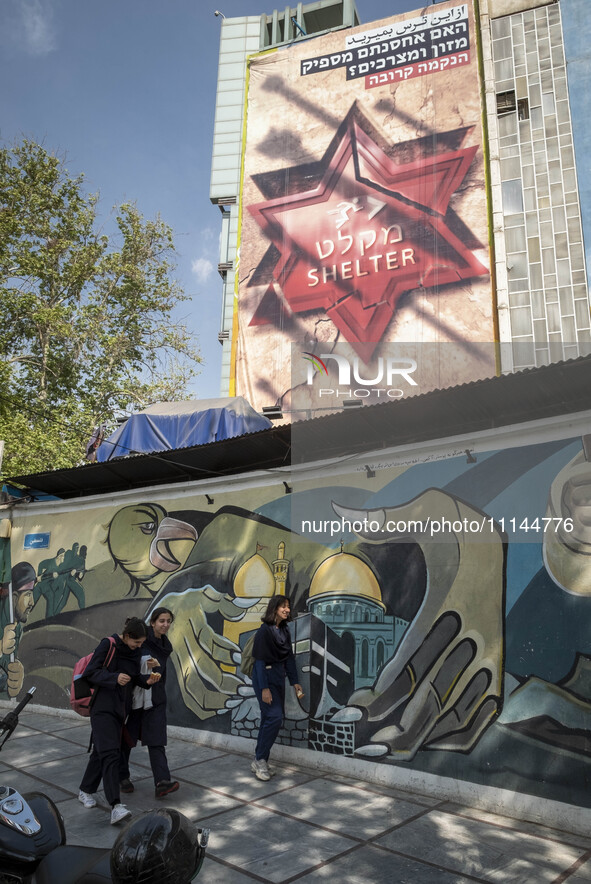 Young Iranian women are walking under anti-Israeli murals in downtown Tehran, Iran, on April 13, 2024. The Prime Minister of Israel, Benjami...