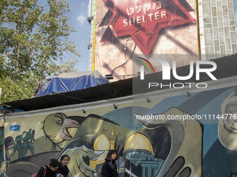 Young Iranian women are walking under anti-Israeli murals in downtown Tehran, Iran, on April 13, 2024. The Prime Minister of Israel, Benjami...