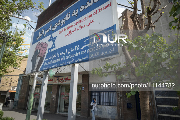 An Iranian woman is walking under an anti-Israeli billboard in downtown Tehran, Iran, on April 13, 2024. The Prime Minister of Israel, Benja...