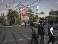 Young Iranian men are crossing a street while an anti-Israeli mural is visible on a wall in downtown Tehran, Iran, on April 13, 2024. The Pr...