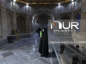 A veiled Iranian woman, responsible for enjoining good and forbidding evil, is standing at the Grand Bazaar in southern Tehran, Iran, on Apr...