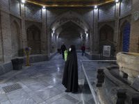 A veiled Iranian woman, responsible for enjoining good and forbidding evil, is standing at the Grand Bazaar in southern Tehran, Iran, on Apr...