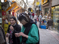 Two young Iranian women, who are not wearing mandatory headscarves, are walking together along a street near the Grand Bazaar in southern Te...