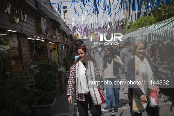 Iranian women, who are not wearing mandatory headscarves, are walking together along a street near the Grand Bazaar in southern Tehran, Iran...