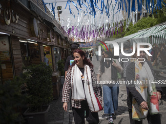 Iranian women, who are not wearing mandatory headscarves, are walking together along a street near the Grand Bazaar in southern Tehran, Iran...