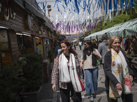 Iranian women, who are not wearing mandatory headscarves, are walking together along a street near the Grand Bazaar in southern Tehran, Iran...