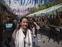 Iranian women, who are not wearing mandatory headscarves, are walking together along a street near the Grand Bazaar in southern Tehran, Iran...