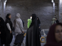 A veiled Iranian official responsible for enjoining good and forbidding evil is monitoring women at the Grand Bazaar in southern Tehran, Ira...