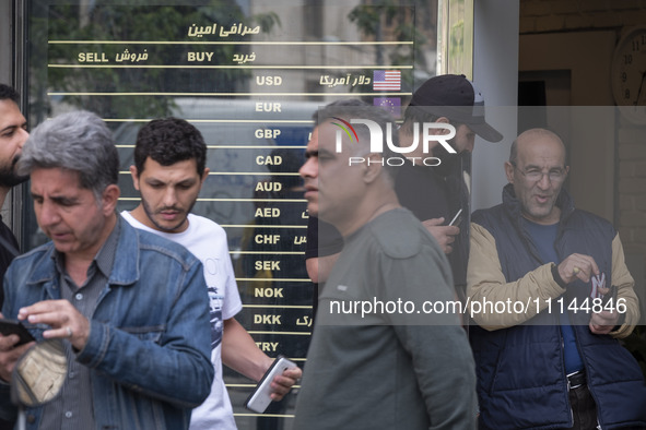 Iranian street money changers are standing outside a currency exchange shop in Tehran's business district, Iran, on April 13, 2024. Meanwhil...