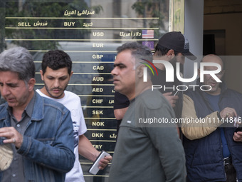 Iranian street money changers are standing outside a currency exchange shop in Tehran's business district, Iran, on April 13, 2024. Meanwhil...