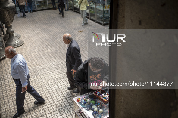 An Iranian man is looking at gemstones while shopping at the Grand Bazaar in southern Tehran, Iran, on April 13, 2024. Meanwhile, the Prime...