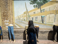 An Iranian woman is walking past mannequins placed on a sidewalk near the Grand Bazaar in southern Tehran, Iran, on April 13, 2024. Meanwhil...