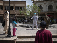 An Iranian street artist is performing on a sidewalk near the Grand Bazaar in southern Tehran, Iran, on April 13, 2024. Meanwhile, the Prime...