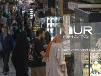 An Iranian couple is looking at a gold shop window while shopping at the Grand Bazaar in southern Tehran, Iran, on April 13, 2024. Meanwhile...