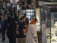 An Iranian couple is looking at a gold shop window while shopping at the Grand Bazaar in southern Tehran, Iran, on April 13, 2024. Meanwhile...