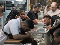 Two Iranian women are speaking with each other while shopping at the Grand Bazaar in southern Tehran, Iran, on April 13, 2024. Meanwhile, th...