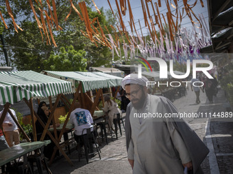 An Iranian cleric is walking along a street near the Grand Bazaar in southern Tehran, Iran, on April 13, 2024. Meanwhile, the Prime Minister...