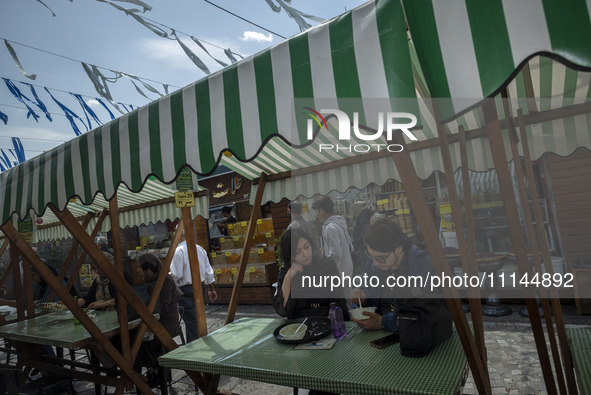 A young Iranian man and a young Iranian woman are sitting together at an outdoor fast-food restaurant in Tehran, Iran, on April 13, 2024. Th...