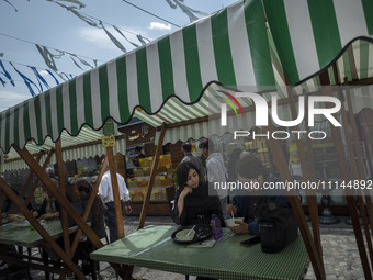 A young Iranian man and a young Iranian woman are sitting together at an outdoor fast-food restaurant in Tehran, Iran, on April 13, 2024. Th...