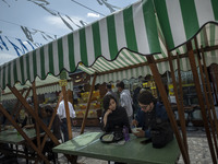 A young Iranian man and a young Iranian woman are sitting together at an outdoor fast-food restaurant in Tehran, Iran, on April 13, 2024. Th...