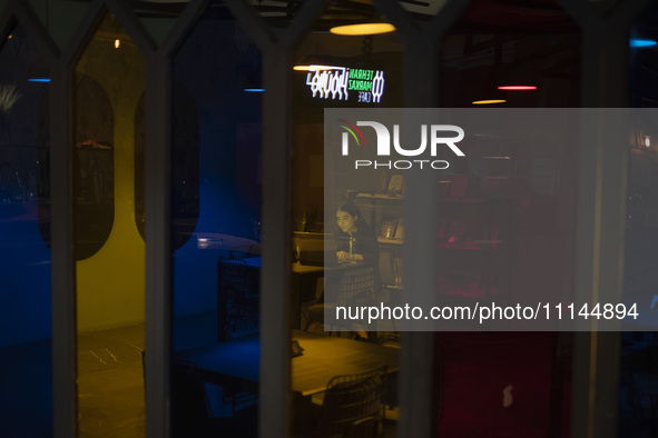 A young Iranian woman is sitting at a cafe in downtown Tehran, Iran, on April 13, 2024. The Prime Minister of Israel, Benjamin Netanyahu, is...