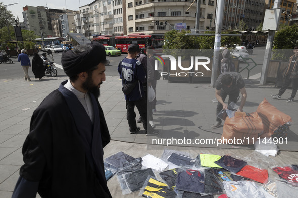 An Iranian cleric is walking past a vendor on a sidewalk in downtown Tehran, Iran, on April 13, 2024. Meanwhile, the Prime Minister of Israe...