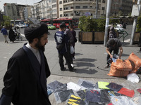 An Iranian cleric is walking past a vendor on a sidewalk in downtown Tehran, Iran, on April 13, 2024. Meanwhile, the Prime Minister of Israe...