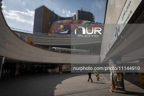 An Iranian woman is walking under a massive banner featuring an image of the al-Aqsa mosque in downtown Tehran, Iran, on April 13, 2024. The...