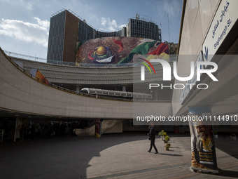 An Iranian woman is walking under a massive banner featuring an image of the al-Aqsa mosque in downtown Tehran, Iran, on April 13, 2024. The...