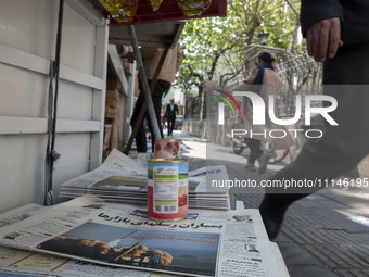 An Iranian man is walking past a Jam-e Jam daily newspaper featuring an image of Iranian surface-to-surface missiles on its front page in do...