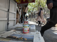 An Iranian man is walking past a Jam-e Jam daily newspaper featuring an image of Iranian surface-to-surface missiles on its front page in do...