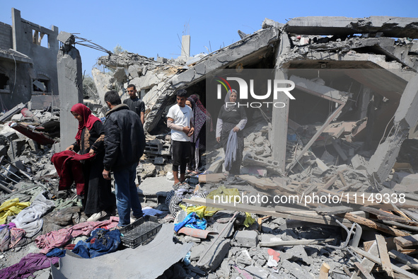 Palestinians are inspecting the damage to a building following Israeli bombardment in the Maghazi camp for Palestinian refugees in the centr...