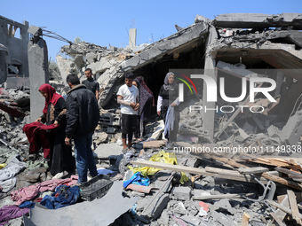 Palestinians are inspecting the damage to a building following Israeli bombardment in the Maghazi camp for Palestinian refugees in the centr...