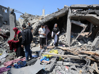 Palestinians are inspecting the damage to a building following Israeli bombardment in the Maghazi camp for Palestinian refugees in the centr...