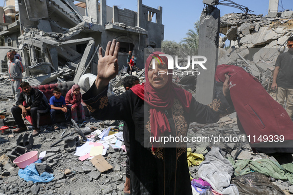 Palestinians are inspecting the damage to a building following Israeli bombardment in the Maghazi camp for Palestinian refugees in the centr...