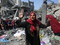 Palestinians are inspecting the damage to a building following Israeli bombardment in the Maghazi camp for Palestinian refugees in the centr...